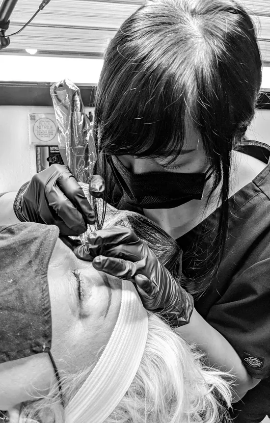 Artist Nancy Lin microblading a female client